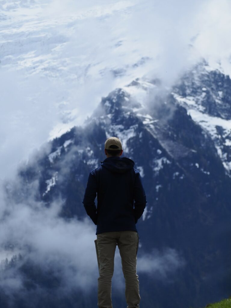 Photo de l'artiste entrepreneur Nicholas PERILLI de dos, depuis les hauteurs de Chamonix, le regard porté vers le Mont Blanc